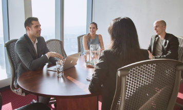 Clients holding a meeting in a fully equipped room with a stunning city view.
