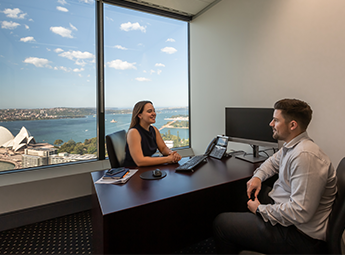 Professionals meeting in a fully equipped serviced office with breathtaking Sydney Harbour views.