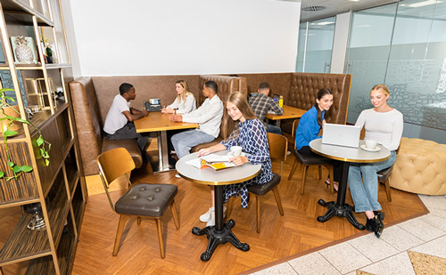 Clients working at The Leadenhall Building coworking space at their hot desks and collaborative booths.