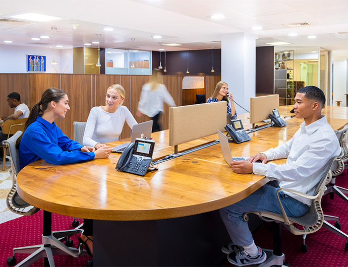 Clients working at a hot desk and taking a call at 1 Mayfair Place coworking space.
