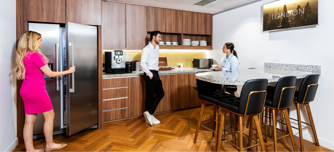 Coworking Space with people networking and collaborating in a fully stocked kitchen.