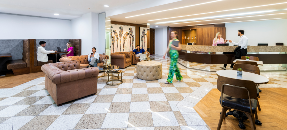 Clients working and networking at 1 Mayfair Place with 5-star interiors, a vibrant reception, and collaborative booths.